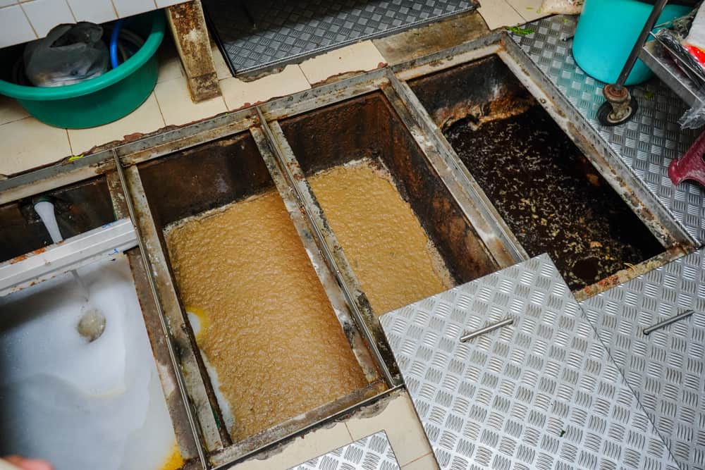 Commercial kitchen grease trap opened for cleaning